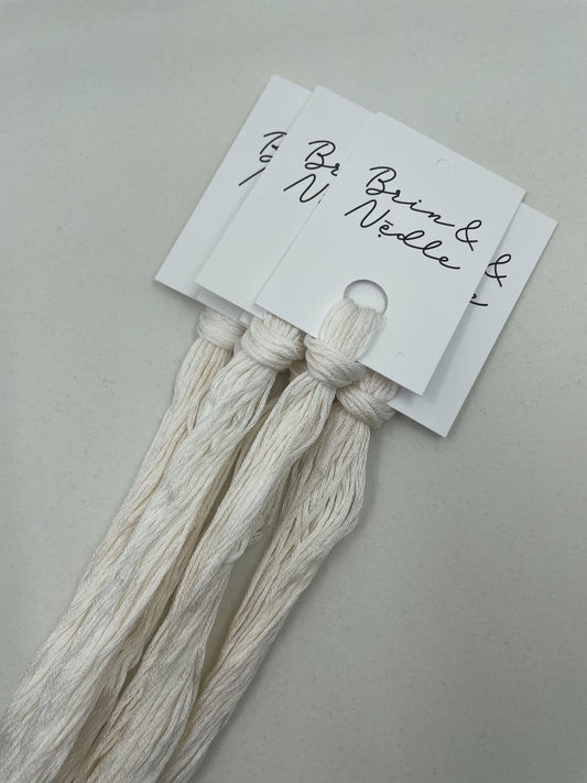Six strand cotton floss with a slight variegated ecru and white