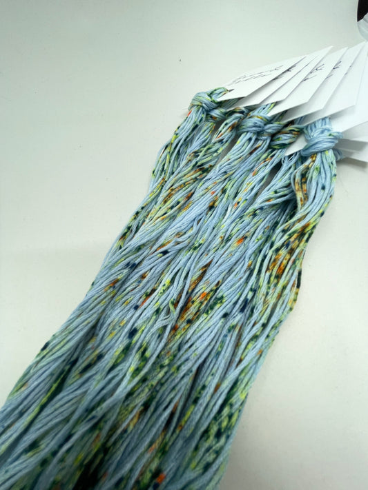Six strand cotton floss with a light blue-green base and spring like green and yellow speckles