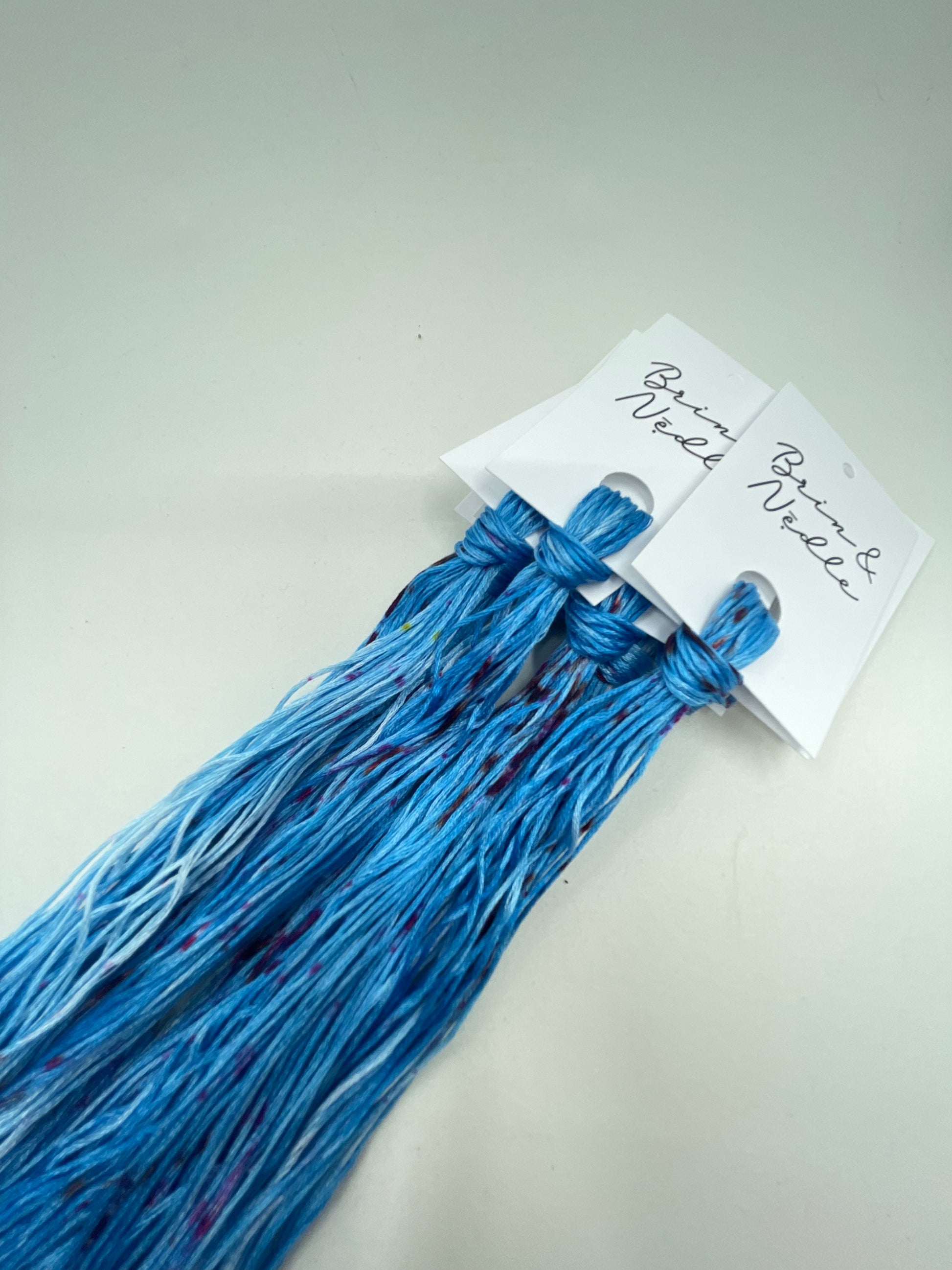 Six strand cotton floss in bright blue with bits of hot pink speckles