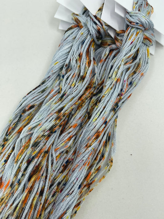 Six strand cotton floss with a grey-blue base and a mash of rusty nails speckles